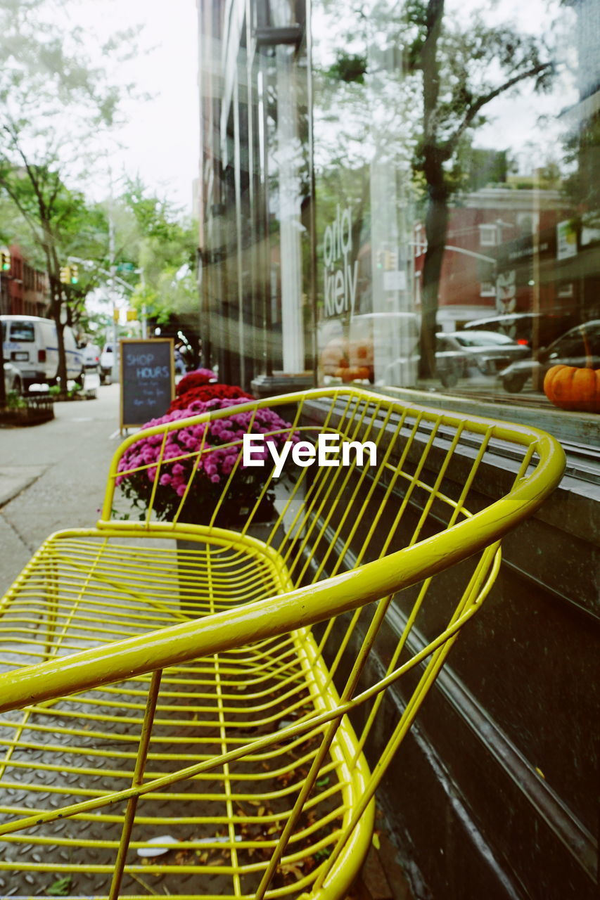 Close-up of yellow metal bench in street