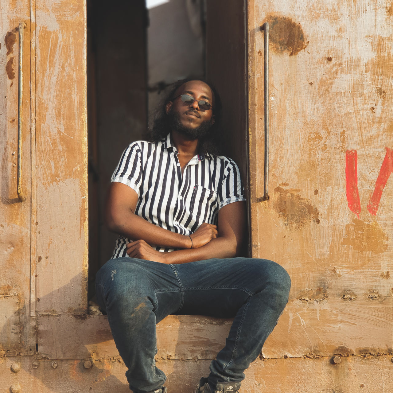 Portrait of young man sitting against old train 