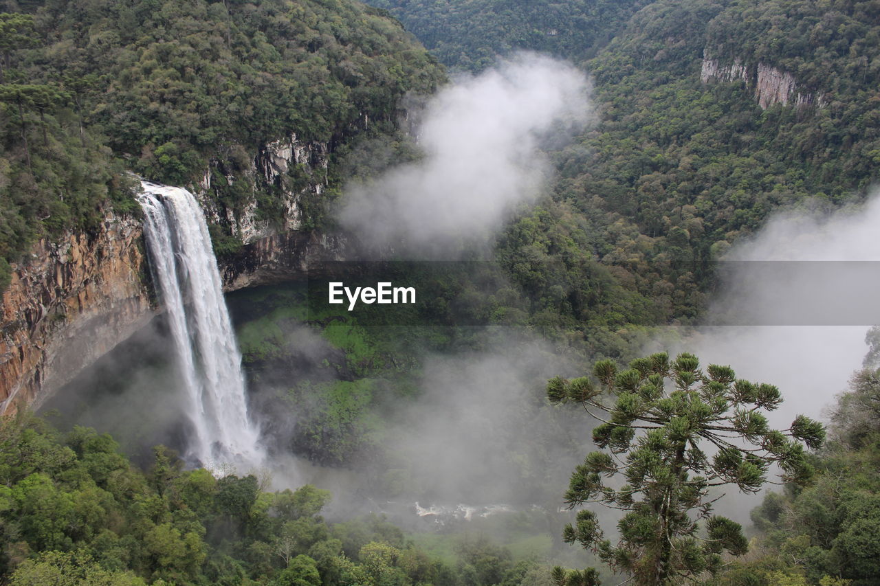 SCENIC VIEW OF WATERFALL IN MOUNTAINS