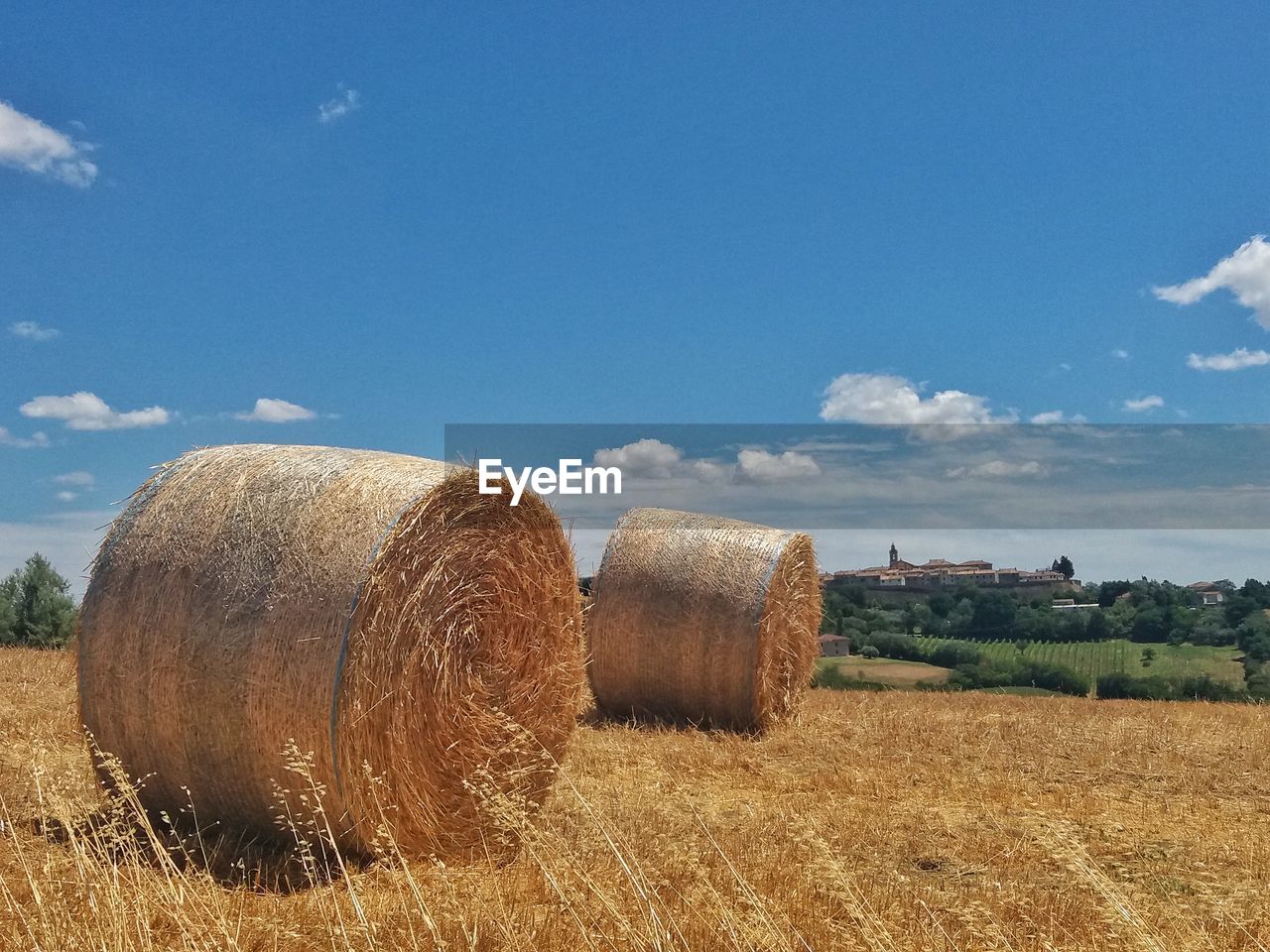 Hay bales on field against sky