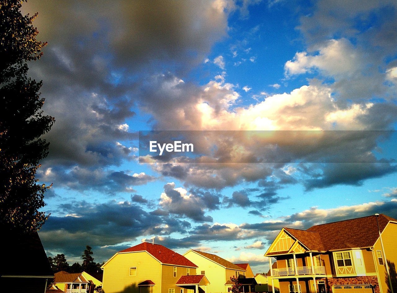 Low angle view of cloudy sky over houses