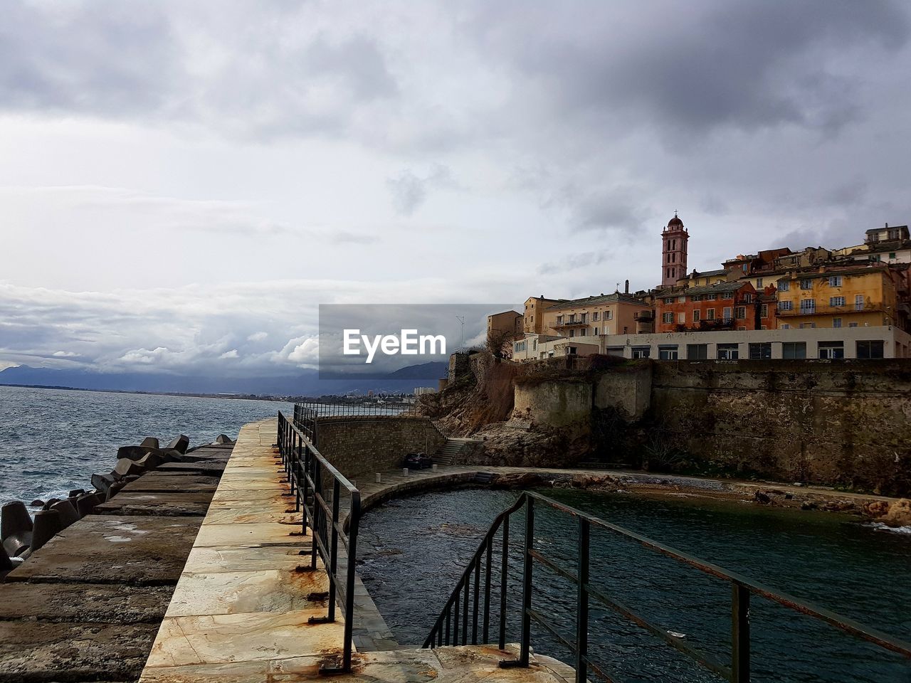 VIEW OF RETAINING WALL BY SEA AGAINST SKY