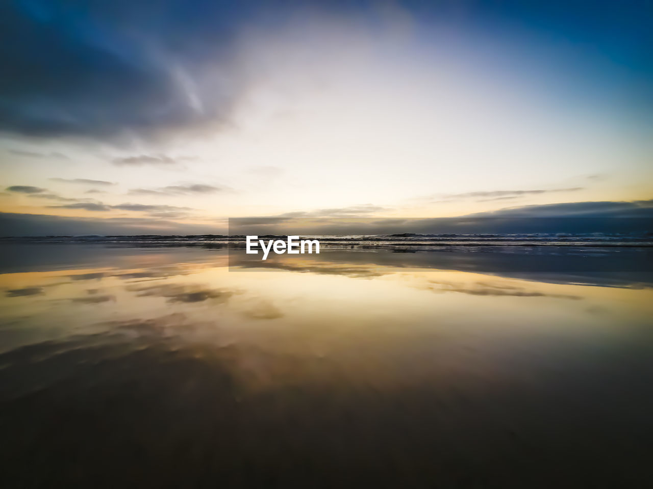 SCENIC VIEW OF BEACH AGAINST SKY AT SUNSET