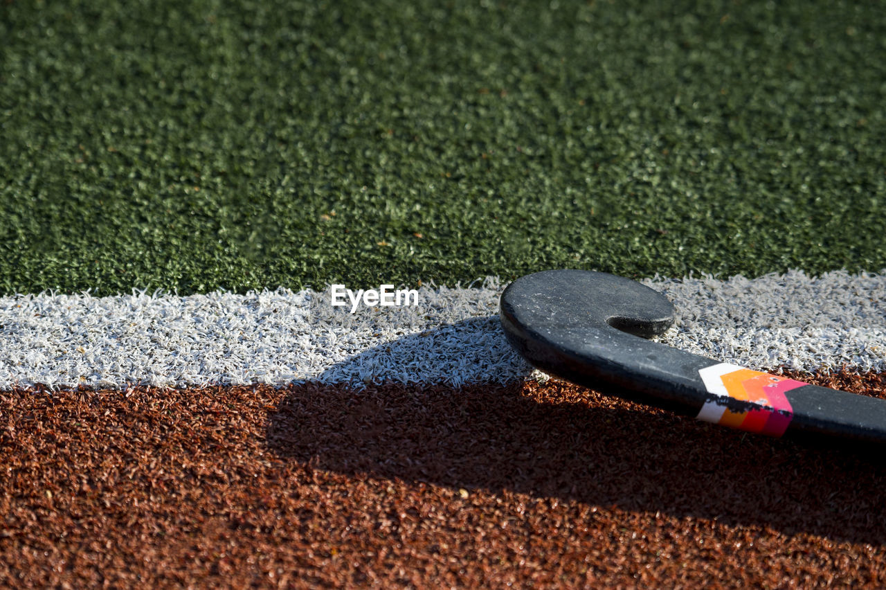 Close-up of hockey stick on playing field