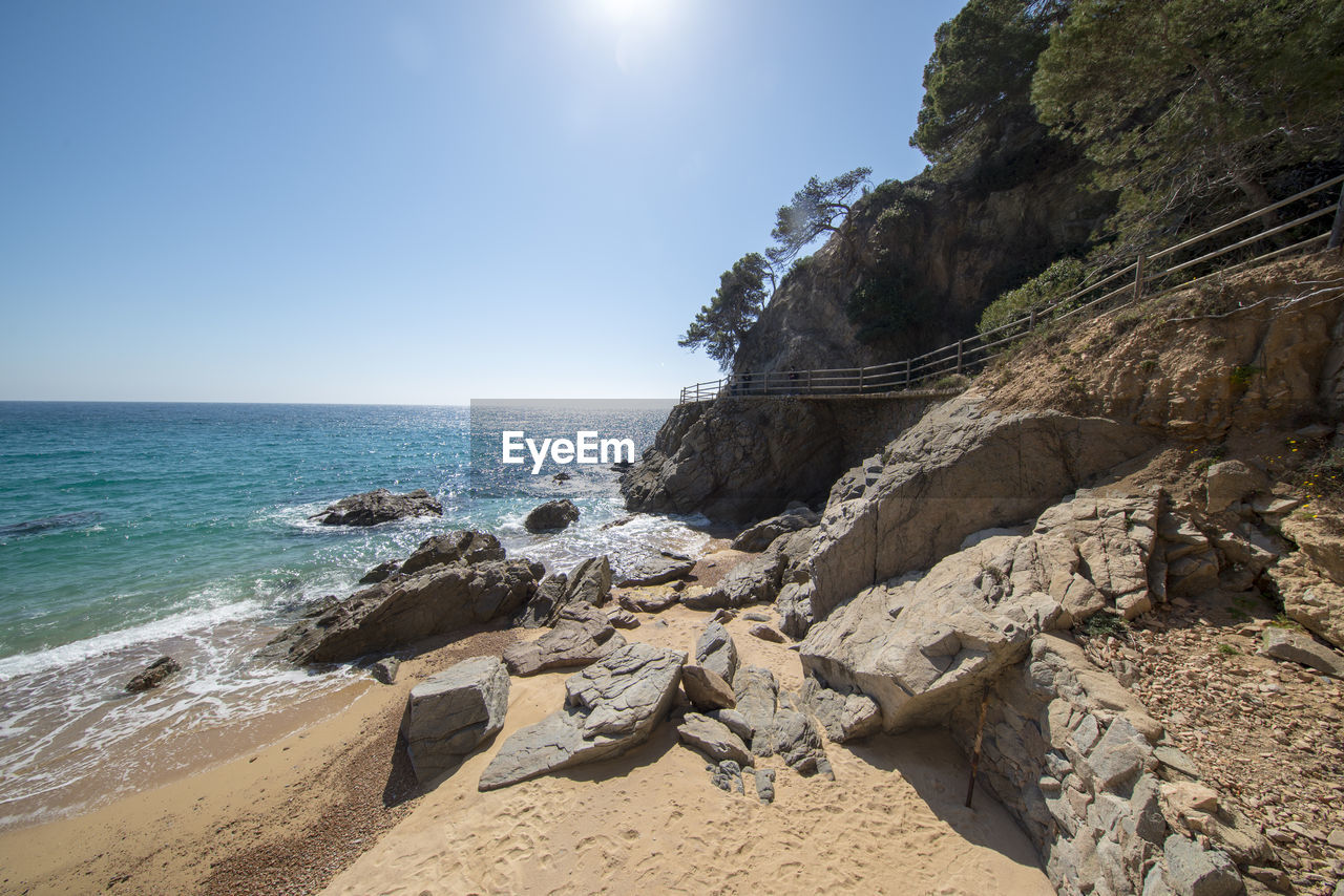 Scenic view of rocks on beach against sky