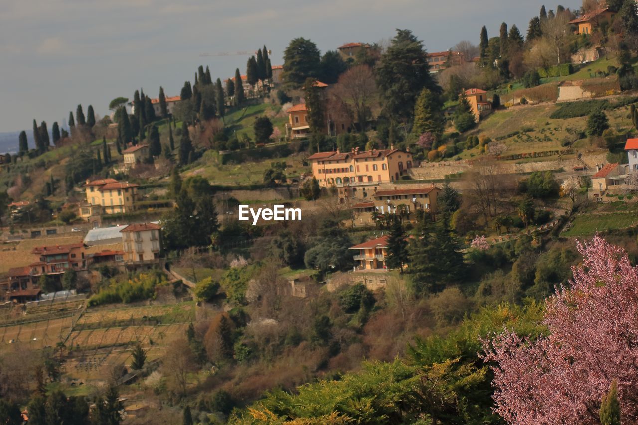 HIGH ANGLE VIEW OF BUILDINGS ON LANDSCAPE AGAINST SKY