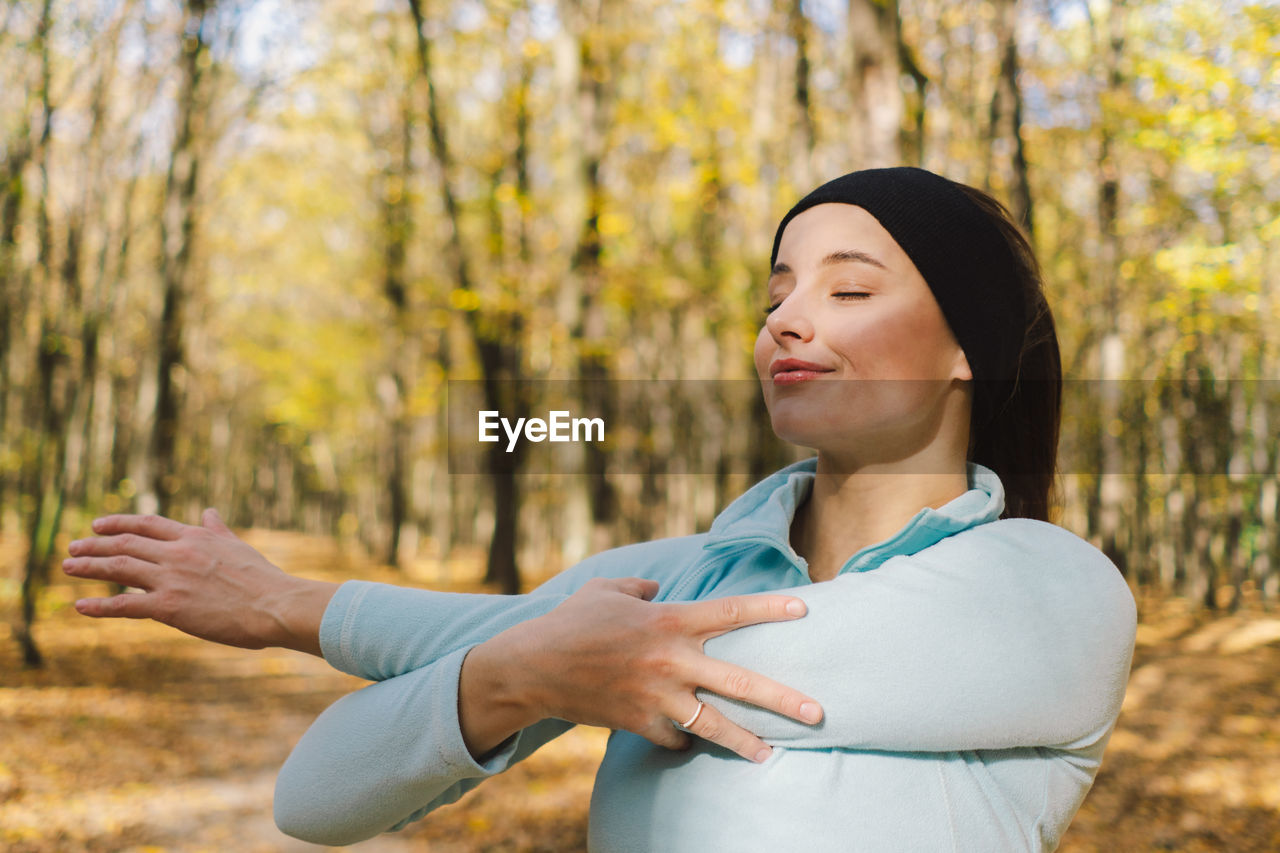 Girl doing fitness in nature on a sunny autumn forest