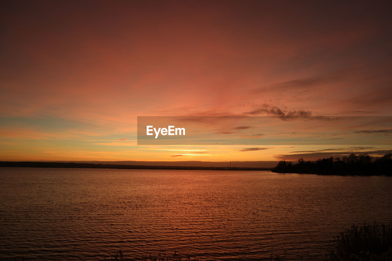 SCENIC VIEW OF SEA AGAINST ORANGE SKY DURING SUNSET