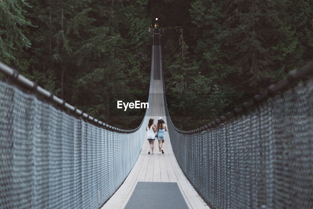 Women walking on rope bridge