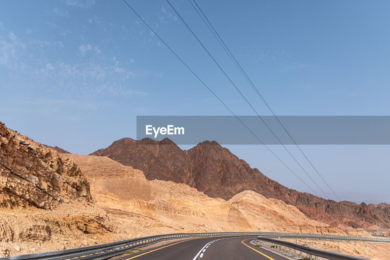 A road next to a mountainous desert landscape. road 12 on the way to eilat, israel, on the egyptian