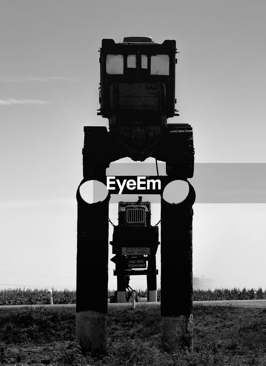 TELEPHONE POLE ON FIELD AGAINST SKY