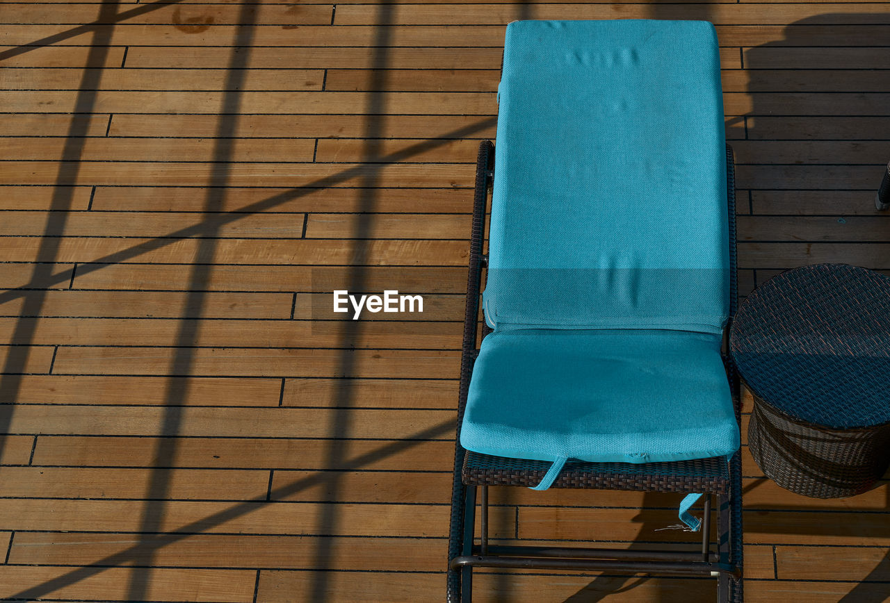 HIGH ANGLE VIEW OF CHAIR ON WOODEN WALL