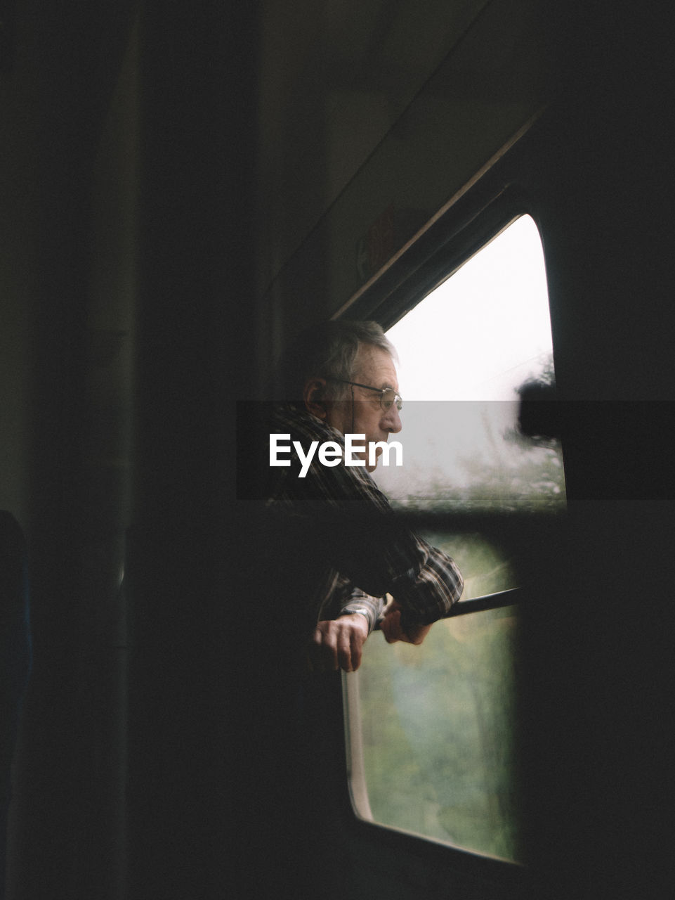 SIDE VIEW OF MAN LOOKING AT WINDOW