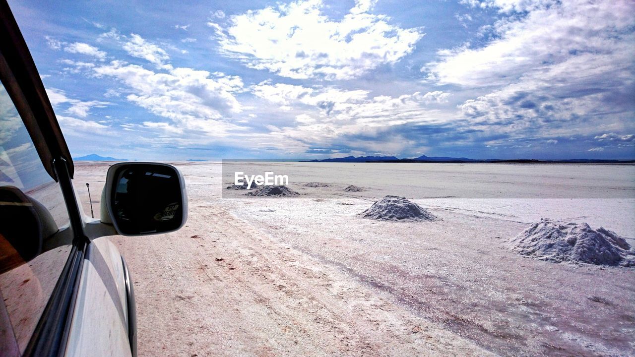 Car on beach against sky