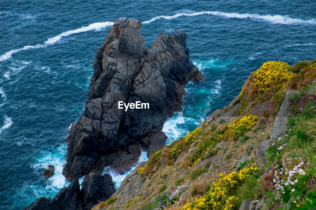 High angle view of rock formation by sea against sky