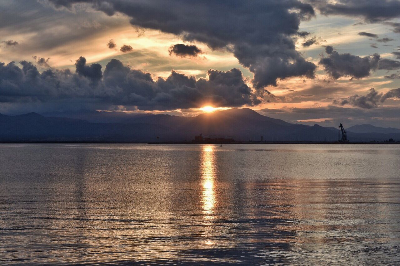 View of sea against mountains during sunset