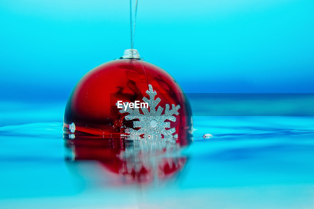 Close-up of red bauble with snowflake in swimming pool