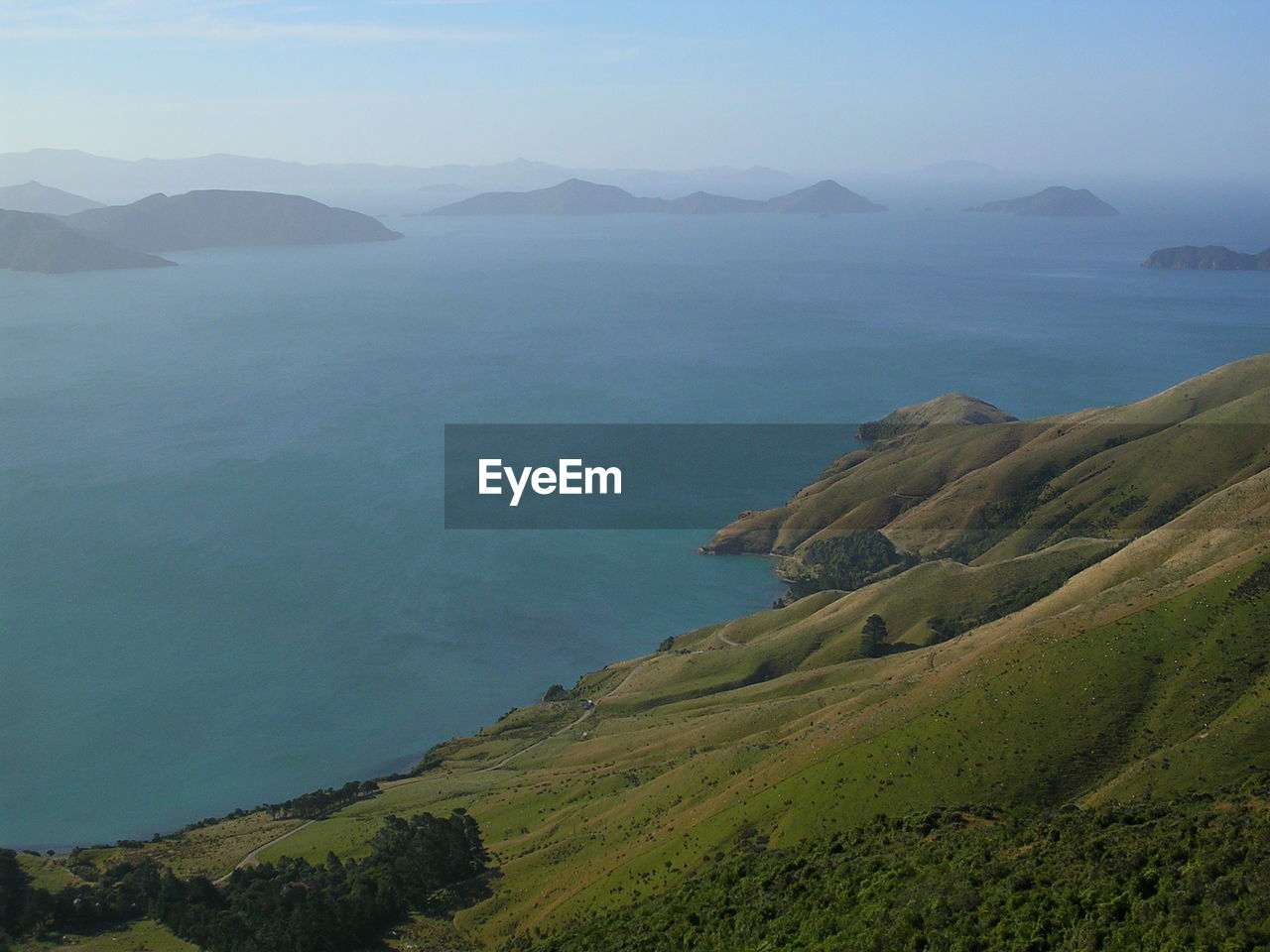 Scenic view of sea by mountains against sky