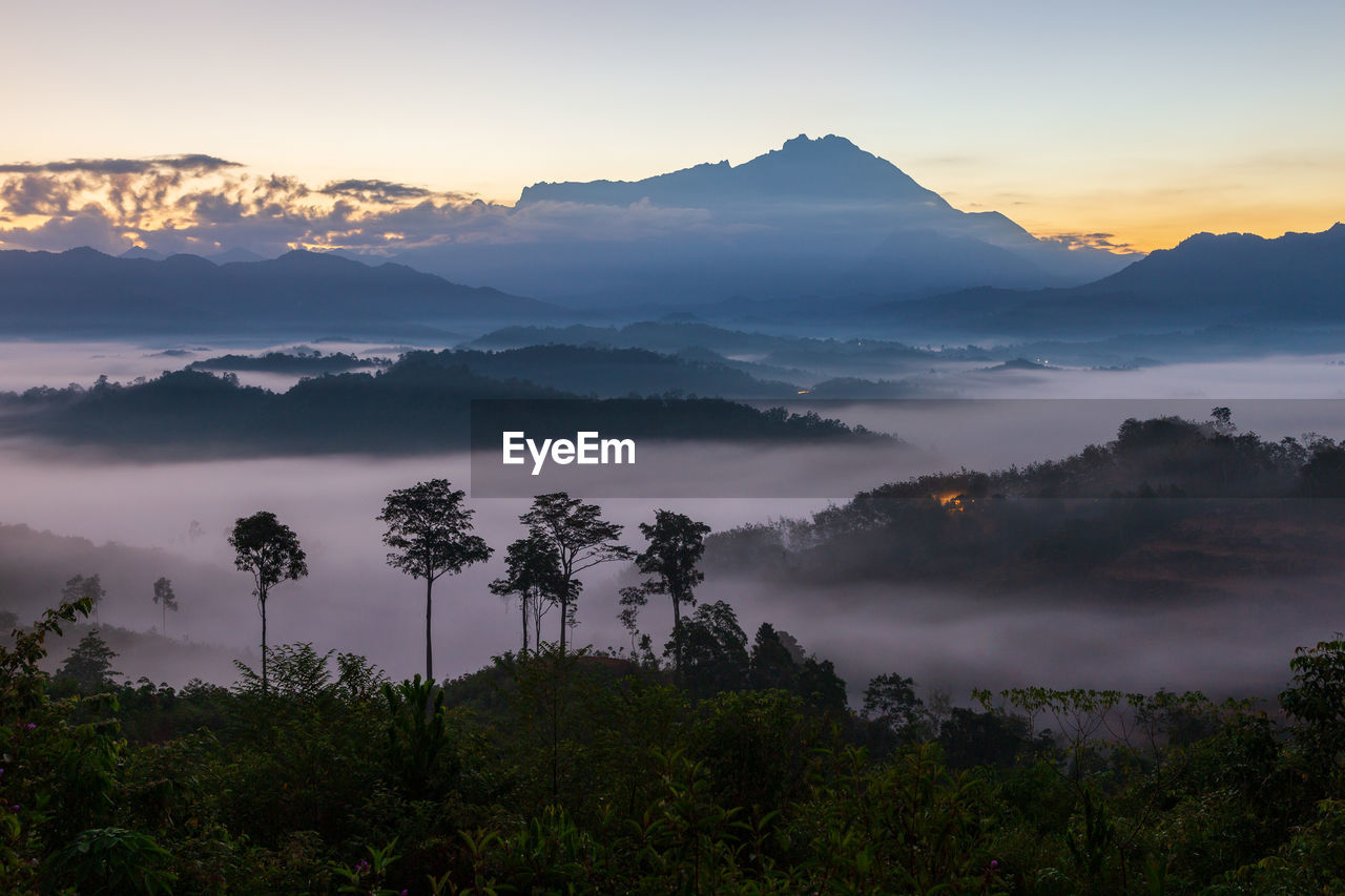 SCENIC VIEW OF SILHOUETTE MOUNTAINS AGAINST SKY AT SUNSET