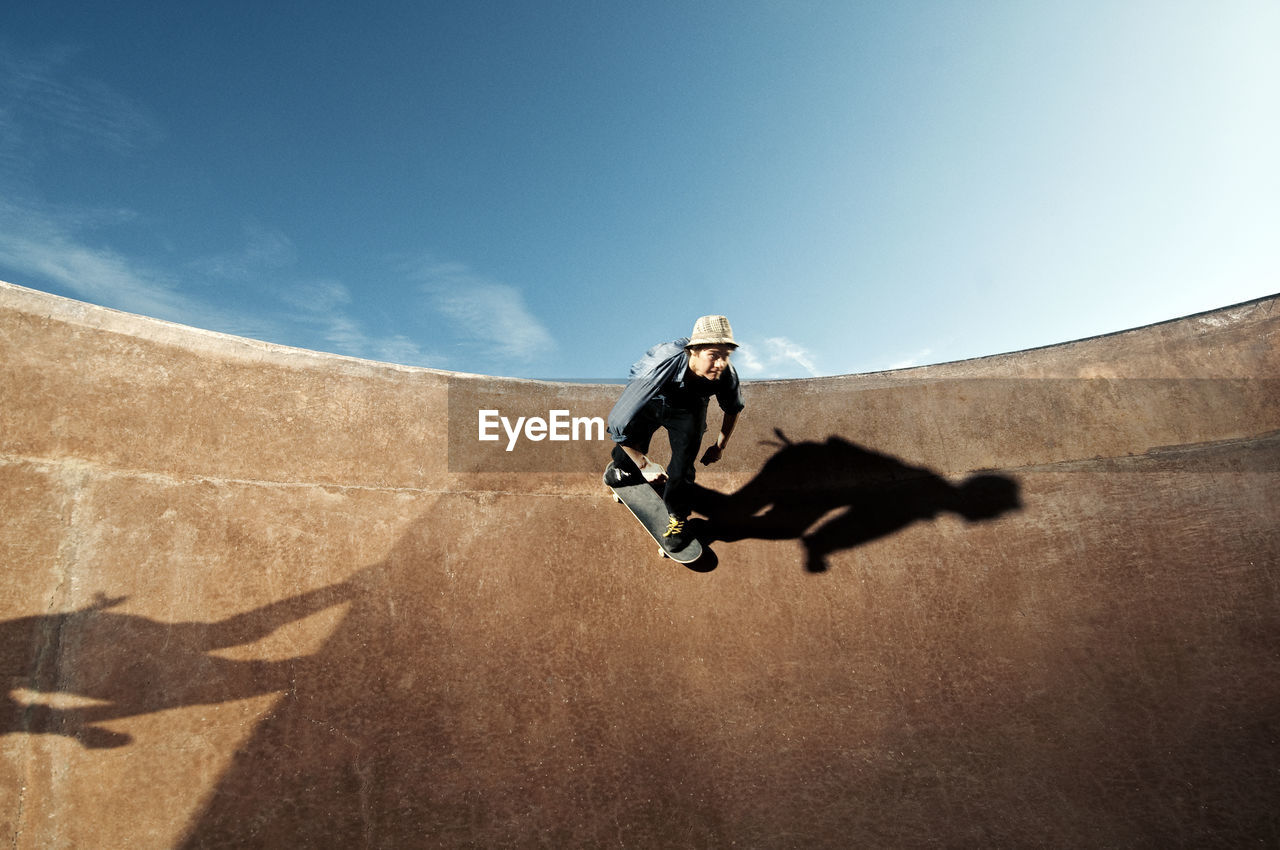 Low angle view of man skateboarding on skate ramp against sky