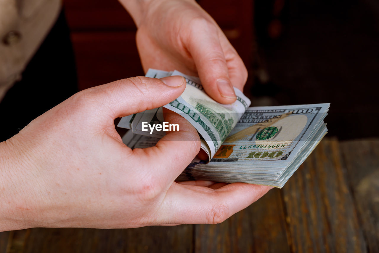 Cropped image of hands counting paper currencies