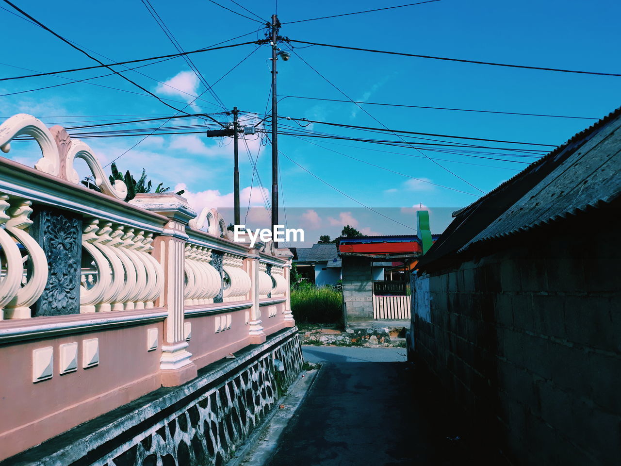 Road amidst buildings in city against sky