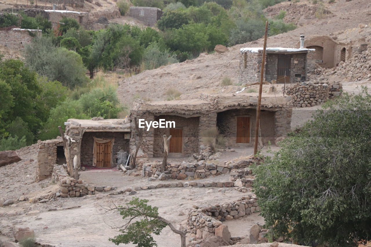 architecture, village, built structure, ruins, building exterior, ancient history, plant, tree, history, building, the past, house, archaeological site, nature, no people, wadi, ancient, day, cob, abandoned, fortification, landscape, old, old ruin, land, outdoors, residential district, damaged, rundown, non-urban scene, growth, mountain, cliff dwelling, ancient civilization, travel destinations, travel, rural scene