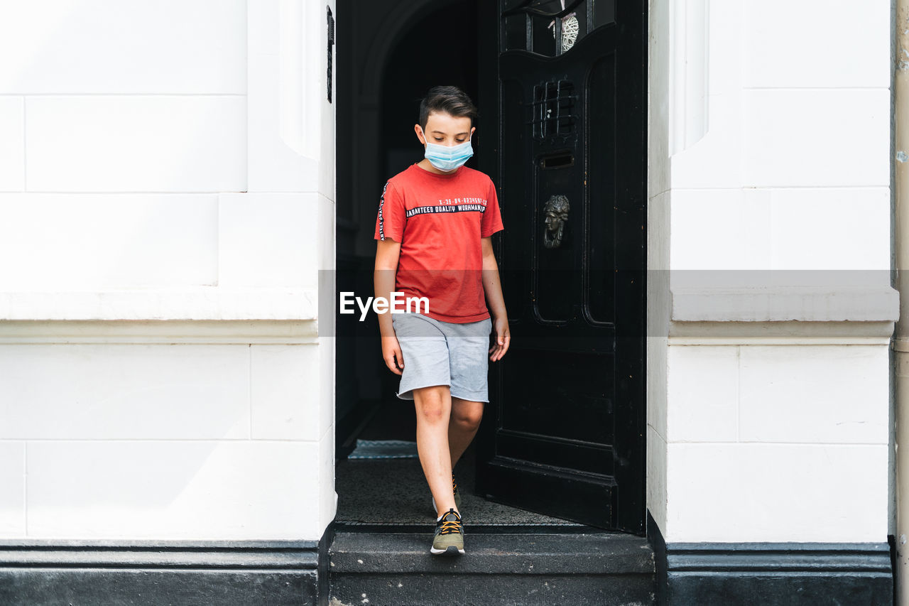 Full length of boy standing against building