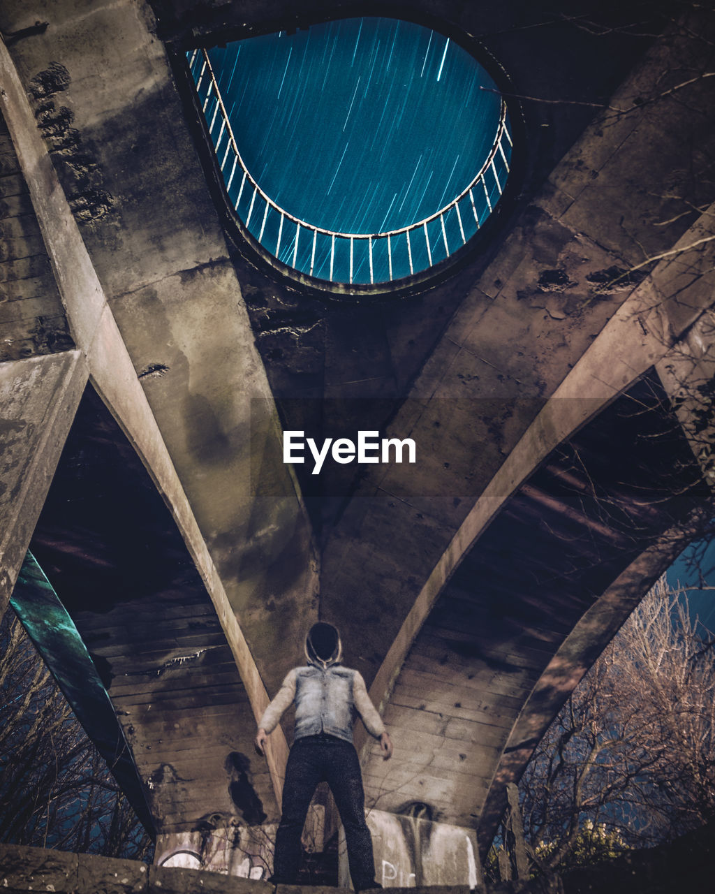 Low angle view of man standing under bridge