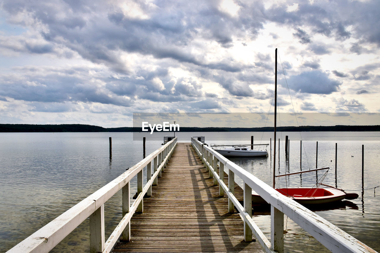 Pier over lake against sky