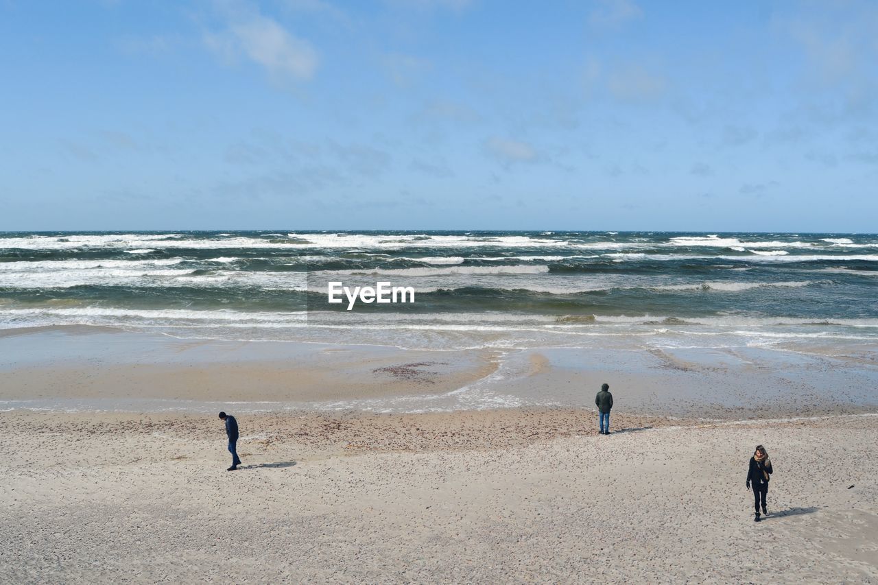 People at beach against sky