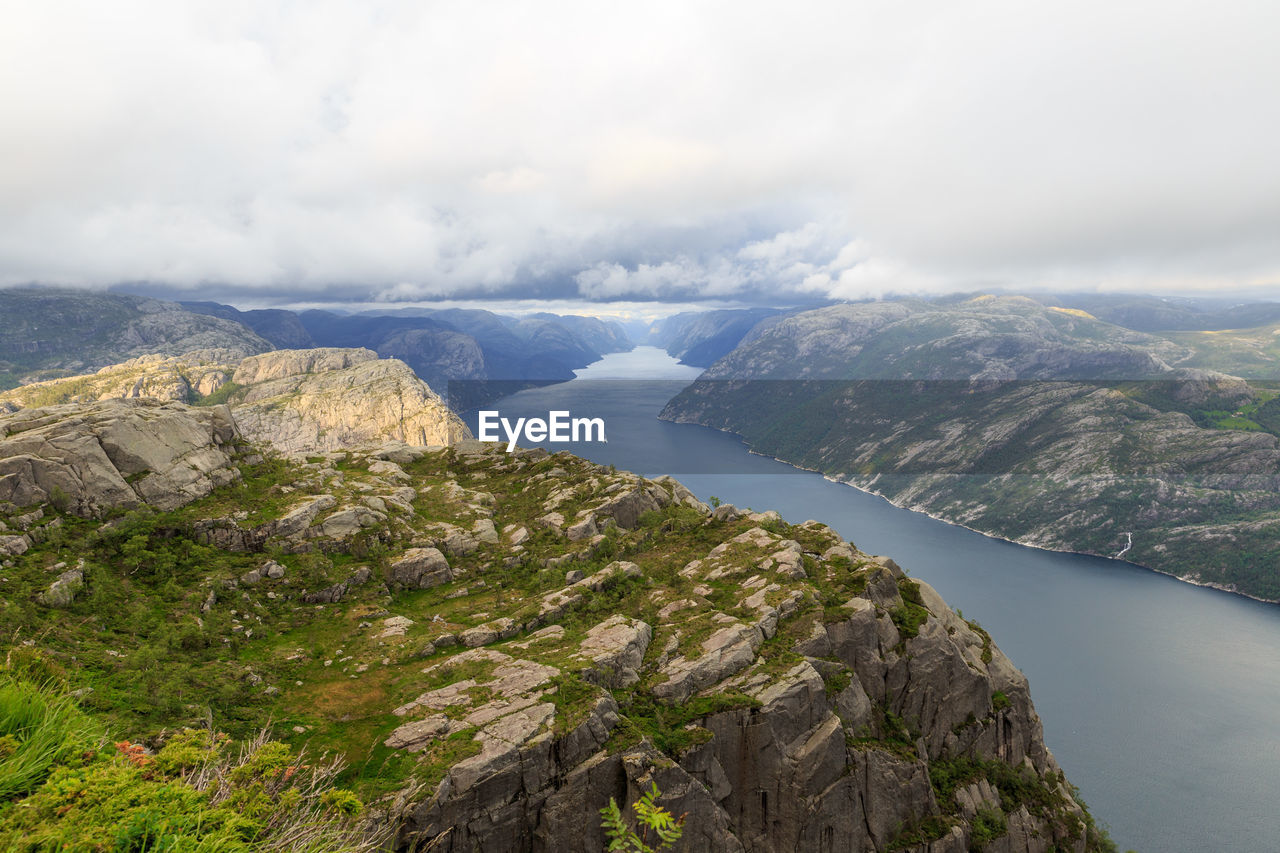 Scenic view of river and mountains against sky