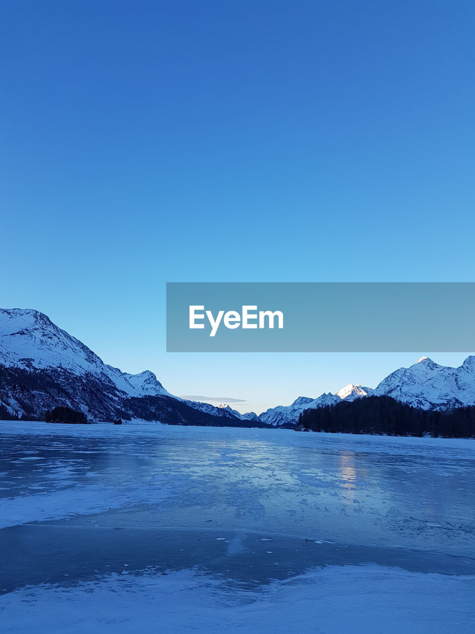 Scenic view of lake against clear blue sky