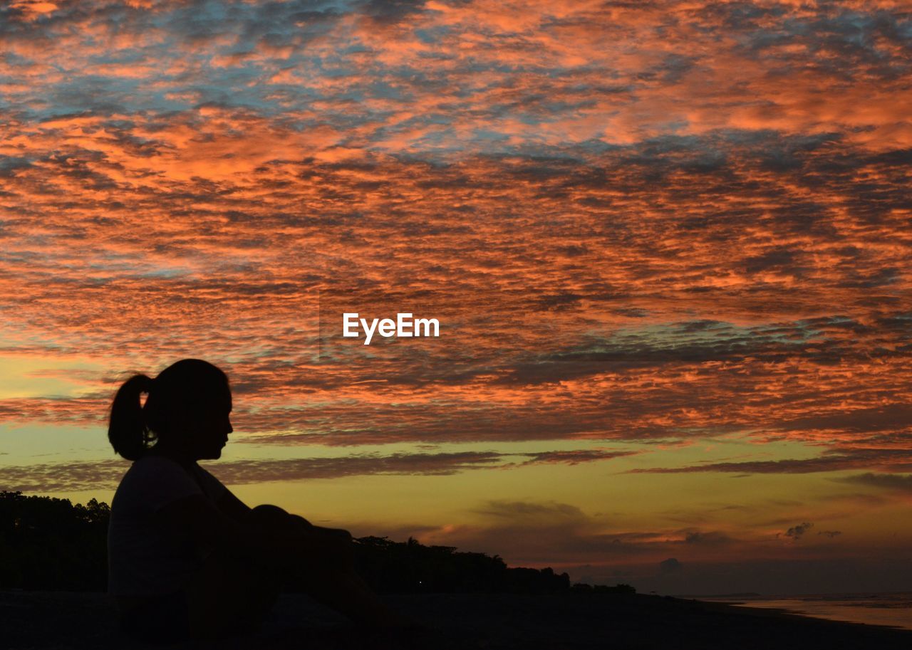 SILHOUETTE MAN WITH UMBRELLA AGAINST SKY DURING SUNSET