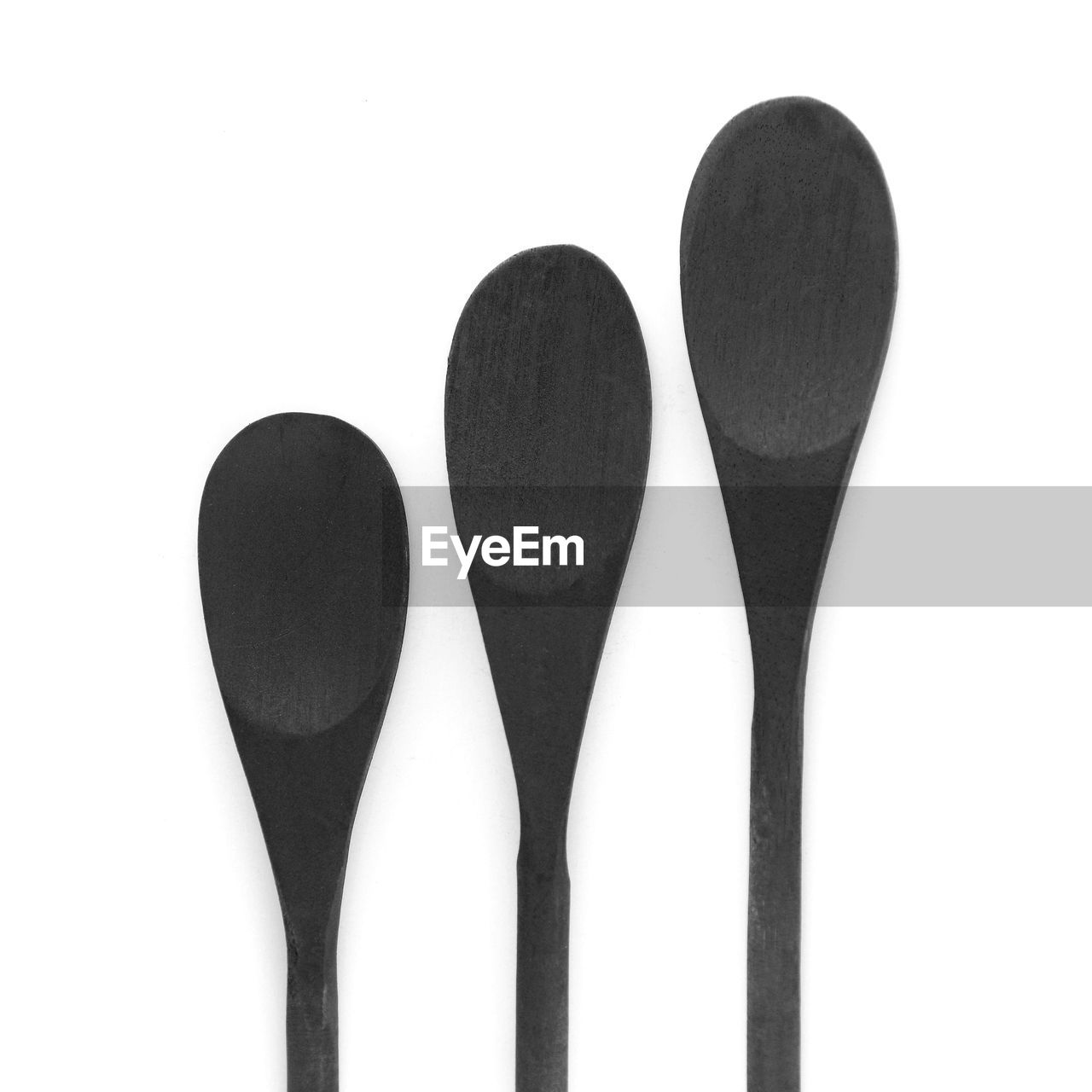 Directly above shot of black spoons on white background