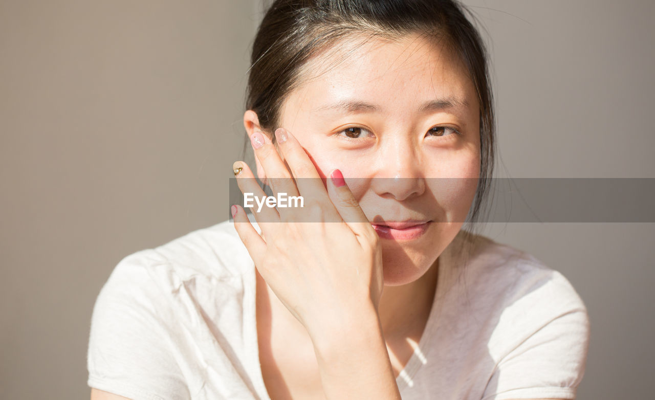 Close-up portrait of woman against wall