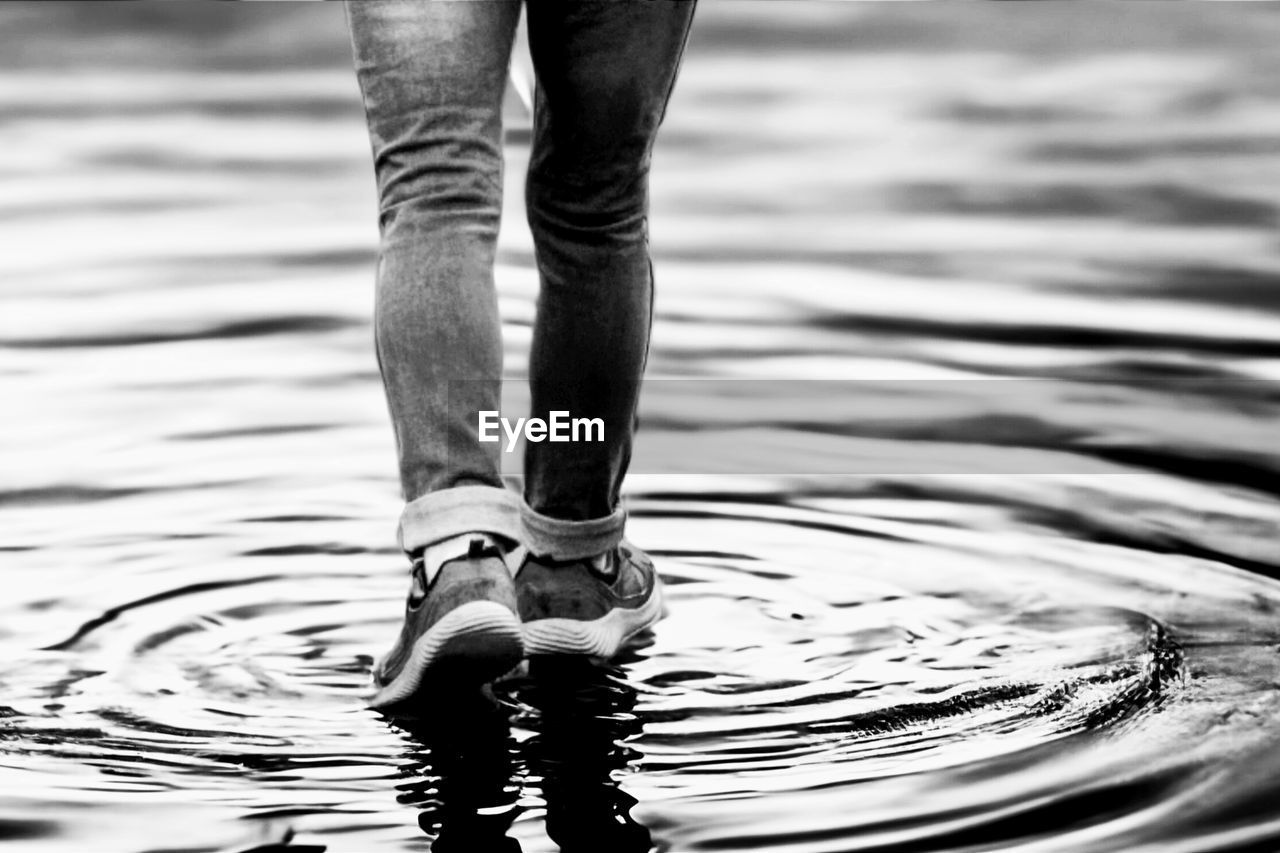 Low section of man standing in water