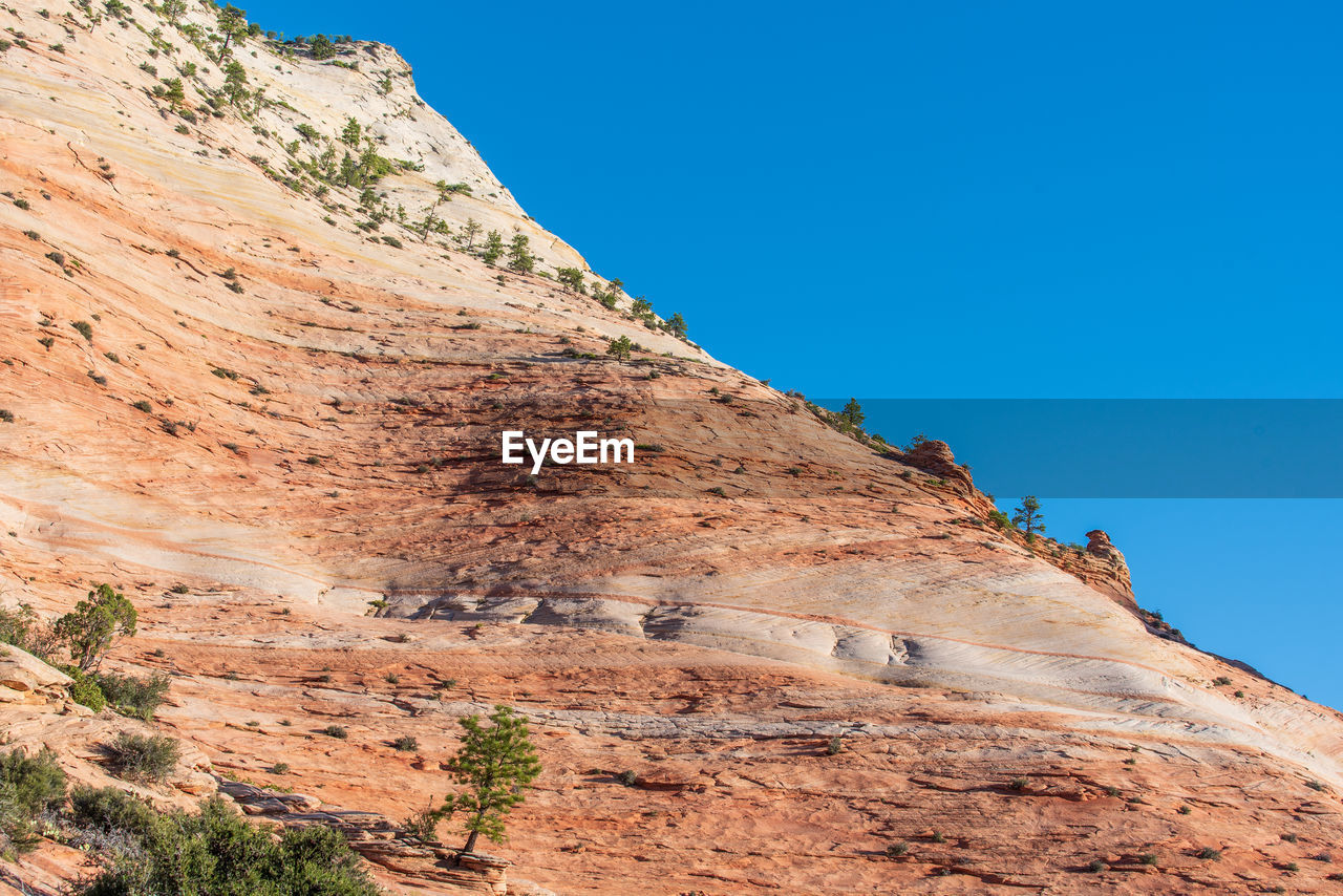 Low angle landscape of orange stone hillside at checkerboard mesa in zion national park