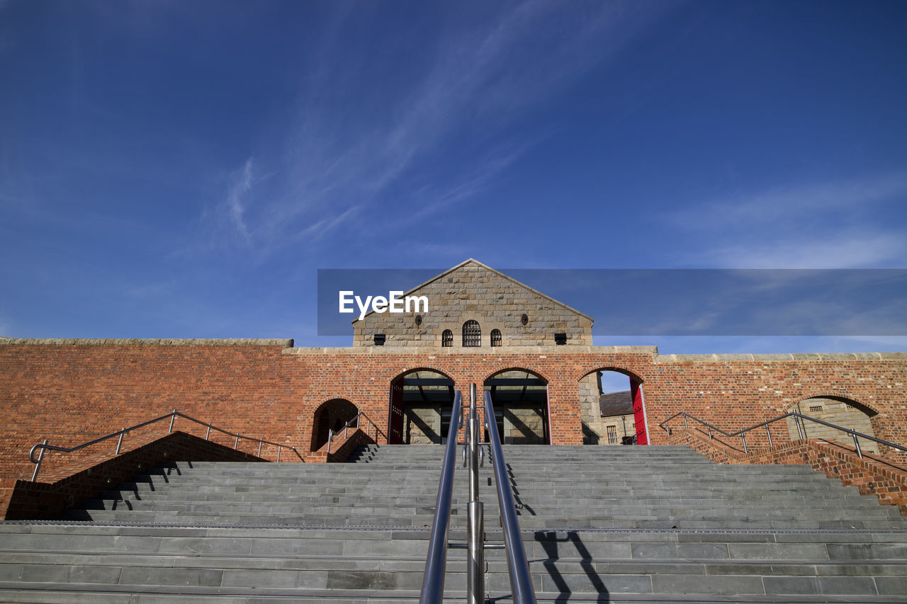 LOW ANGLE VIEW OF STEPS LEADING TOWARDS BLUE SKY