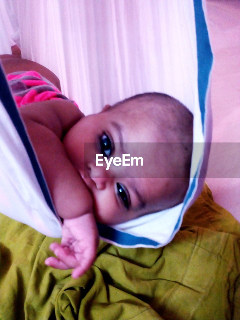 PORTRAIT OF CUTE BABY LYING IN BED