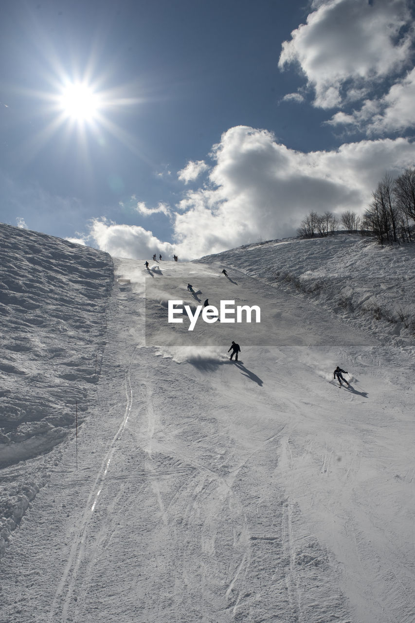 PEOPLE SKIING ON SNOW COVERED FIELD