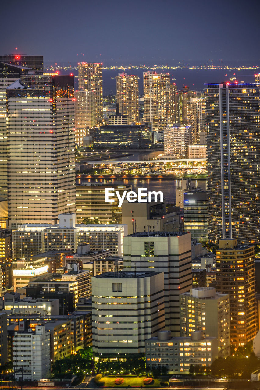 ILLUMINATED CITYSCAPE AGAINST SKY AT NIGHT