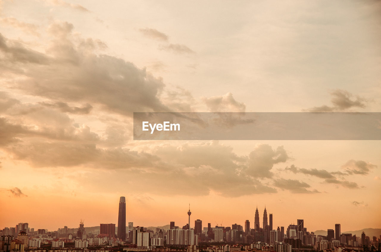 BUILDINGS IN CITY AGAINST CLOUDY SKY