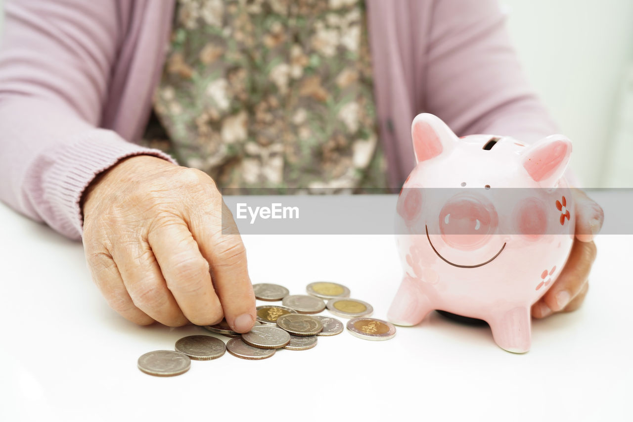 midsection of man putting coin on table