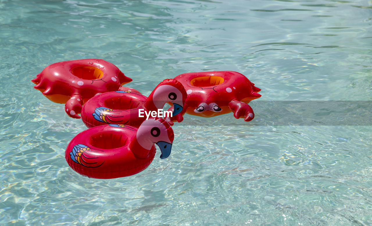 The photo shows different, inflated, cup holders in a pool