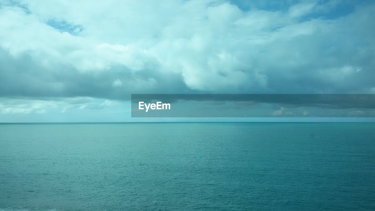 SCENIC VIEW OF SEA AGAINST STORM CLOUD SKY