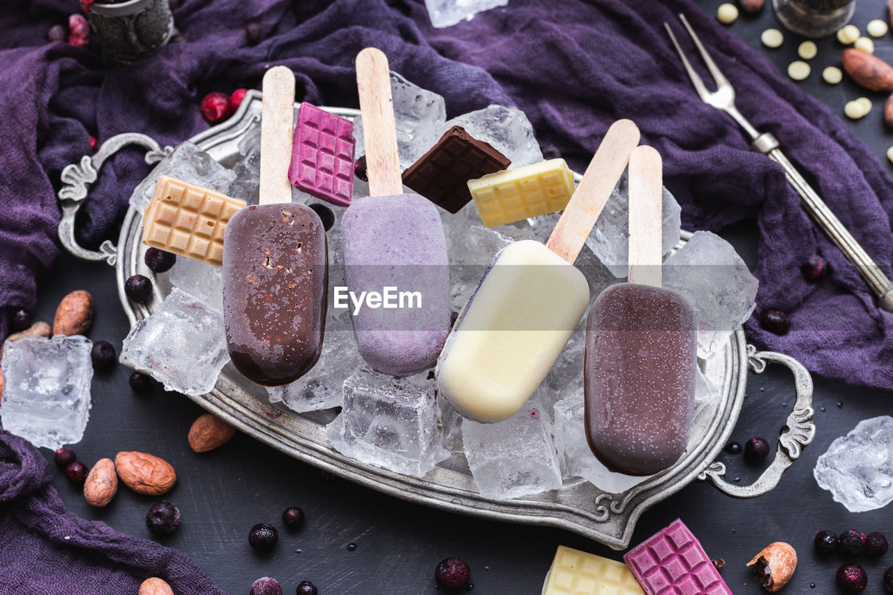 HIGH ANGLE VIEW OF ICE CREAM CONE ON WOODEN TABLE