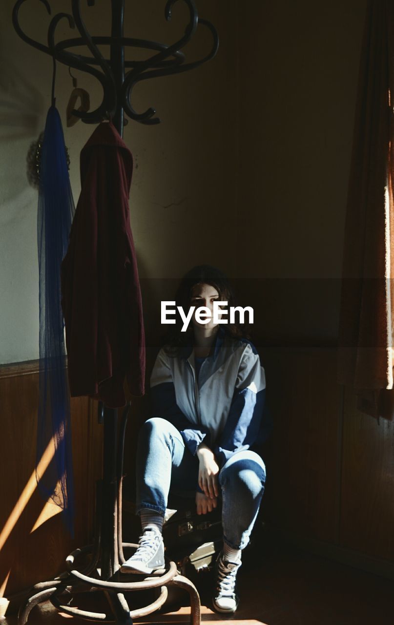 Portrait of woman by old coat rack