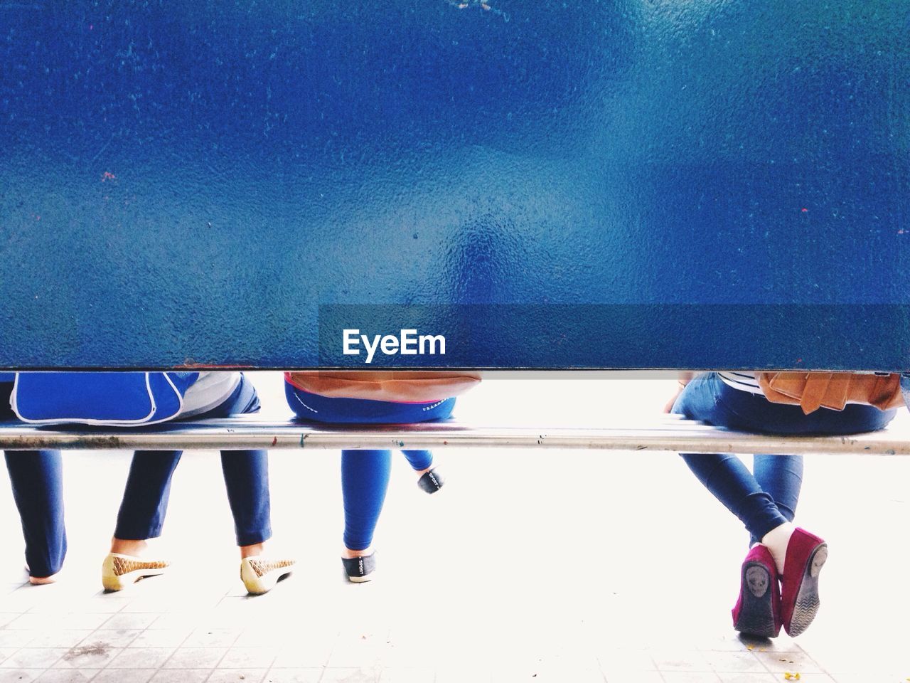 Low section of women sitting on bench