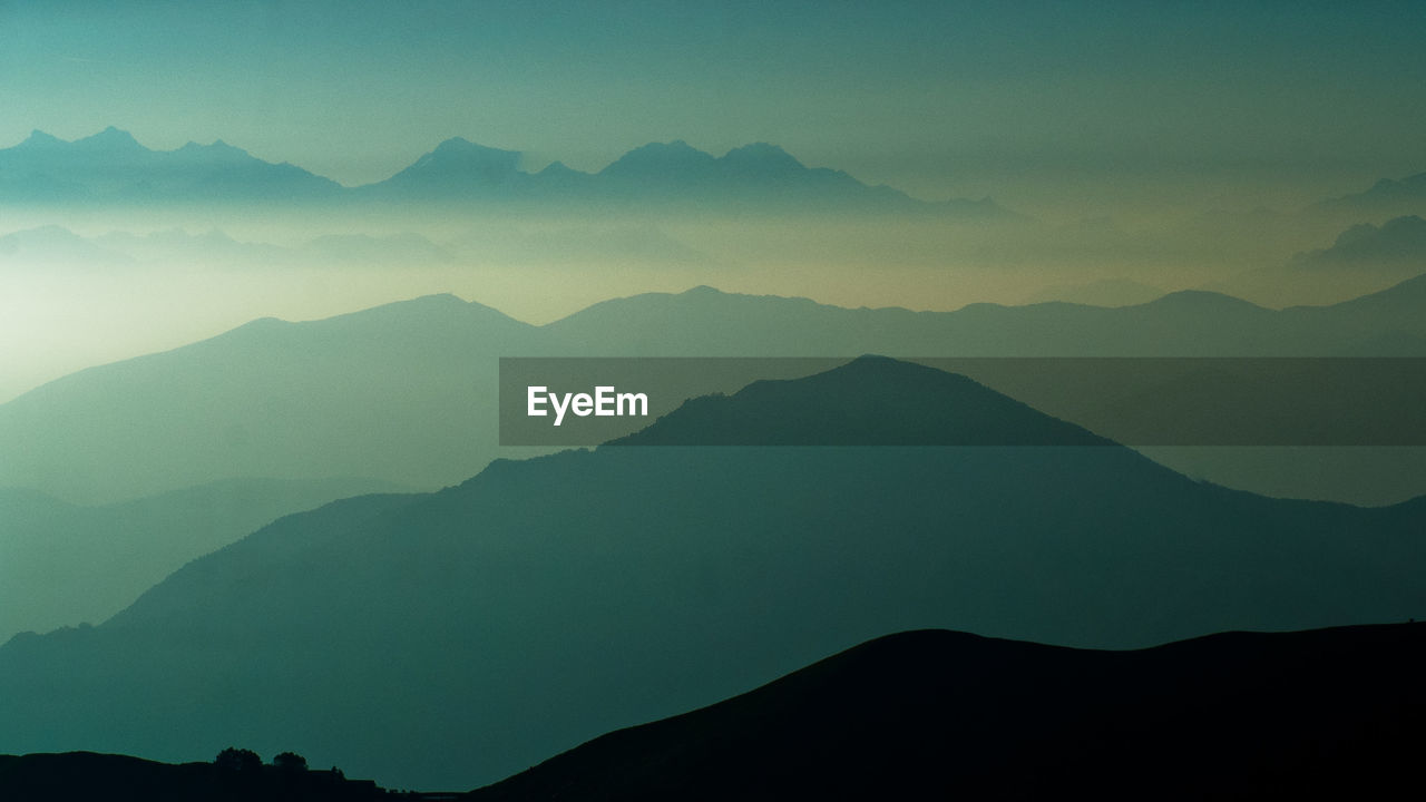 Scenic view of mountains against cloudy sky